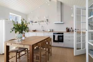 a kitchen with a wooden table and a kitchen with white cabinets at 20414-Samso-Strandvejen-63 in Ballen +28 photos