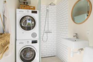 a bathroom with a washing machine and a sink at 20414-Samso-Strandvejen-63 in Ballen