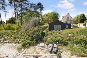 two chairs and a house on a beach at 20414-Samso-Strandvejen-63 in Ballen
