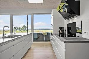 a kitchen with white cabinets and a large window at 20503-Samso-Strandkrogen-37 in Sælvig