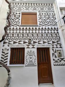 a building with a black and white tiled wall at Vattediko in Pyrgi