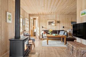 a living room with a fireplace and a couch at 20613-Samso-Halemejsevej-8 in Nordby