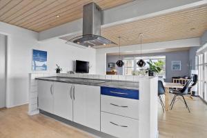 a kitchen with white cabinets and a dining room at 20212-Samso-Saelvig-50 in Sælvig