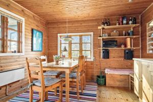 a wooden dining room with a table and chairs at 20613-Samso-Halemejsevej-8 in Nordby