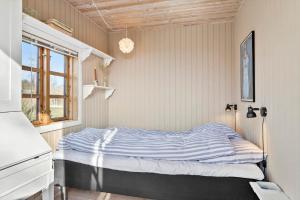 a bedroom with a bed in a room with a window at 20613-Samso-Halemejsevej-8 in Nordby