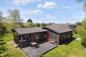 a small cabin with a deck in a field at 20613-Samso-Halemejsevej-8 in Nordby
