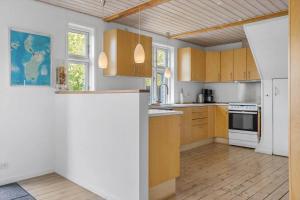 a kitchen with wooden cabinets and white appliances at 20310-Ballen-Strandvejen-8 in Ballen