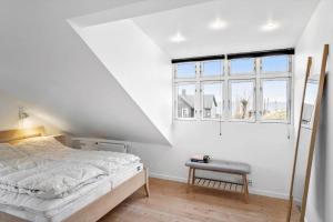 a white bedroom with a bed and a window at 20310-Ballen-Strandvejen-8 in Ballen