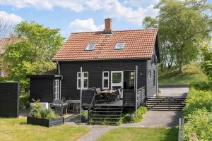 a black house with a porch and stairs to it at 20310-Ballen-Strandvejen-8 in Ballen