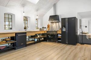 a large kitchen with black appliances and wooden floors at 20417-Samso-Ballenvej-26 in Ballen