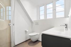 a bathroom with a toilet and a sink and a window at 20417-Samso-Ballenvej-26 in Ballen +29 photos