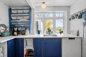 a blue kitchen with a sink and a window at 20322-Samso-Bakkevej-7 in Brundbymark +21 photos