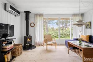 a living room with a blue couch and a wood stove at 20209-Samso-Rosenvej-21 in Tanderup