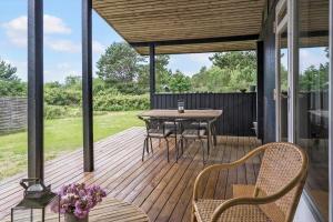 a wooden deck with a table and chairs on it at 20209-Samso-Rosenvej-21 in Tanderup