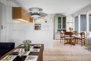 a living room with a table and a dining room at 20209-Samso-Rosenvej-21 in Tanderup +25 photos