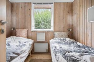 two beds in a room with a window at 20209-Samso-Rosenvej-21 in Tanderup