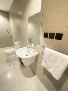 a bathroom with a sink and a toilet and a mirror at المهيدب للشقق الفندقية in Rabigh