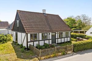 a black and white house with a wooden fence at 20313-Samso-Orby-Hovedgade-53 in Brundbymark