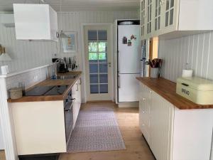 a kitchen with white cabinets and a white refrigerator at 20132-Samso-Skovvejen-7 in Nordby +21 photos