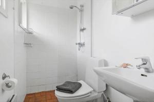 a white bathroom with a toilet and a sink at 20132-Samso-Skovvejen-7 in Nordby