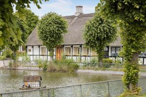 a house in the middle of a river with a boat in it at 20132-Samso-Skovvejen-7 in Nordby