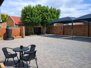 a patio with a table and chairs and umbrellas at Hillcrest Hosting AirBnB in Kimberley