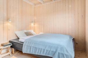 a bedroom with a bed in a wooden wall at 20411-Samso-Nylandsvej-21-C in Ballen