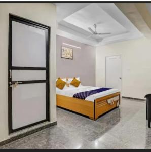 a bedroom with a bed and a large window at Hotel krishna in Mānsa