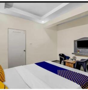a room with a bed and chairs and a desk at Hotel krishna in Mānsa +1 photo