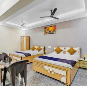 a bedroom with two beds and a table and a chair at Hotel krishna in Mānsa