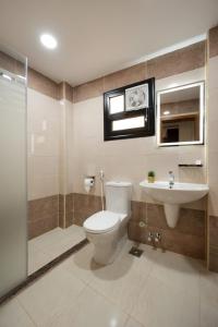 a bathroom with a toilet and a sink and a shower at Elyasmene in Qinā