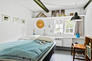 a bedroom with a bed and a desk and a window at 20509-Samso-Egevej-13 in Onsbjerg
