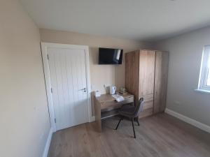 a room with a desk with a chair and a cabinet at Cliff Top Accommodation in Spanish Point