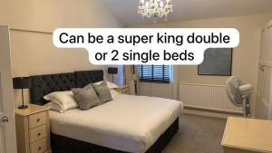 a bedroom with a king sized bed and a chandelier at Townhouse Apartment in Oswestry