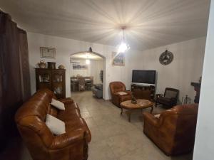 a living room with brown leather furniture and a tv at villa gambotti in Morta