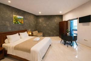 a bedroom with a bed and a desk and a television at Serendipity Bali in Sanur +41 photos