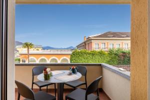 a table and chairs on a balcony with a view of a building at Trilocale Ferruccio in Baveno