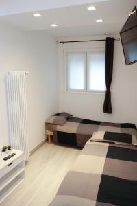a bedroom with two beds and a window at Ca di baragett in Mandello del Lario