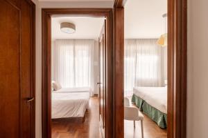 a room with two beds and a door to a bedroom at Trilocale Ferruccio in Baveno