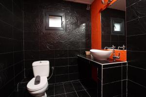 a black bathroom with a toilet and a sink at Hilltop Chalet 5 in Hanioti +7 photos