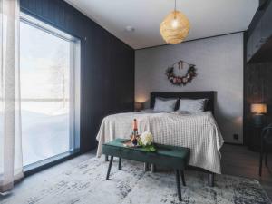 a bedroom with a bed with a table and a window at Arctic Aurora Hideaway in Rovaniemi +29 photos
