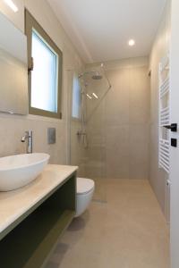 a bathroom with a sink and a toilet and a shower at Anopoli Rooms in Sinoikismós Kámbos