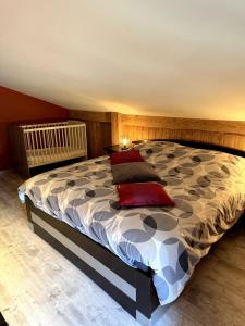 a bedroom with a large bed with red pillows at Les Loutrons in Cornimont