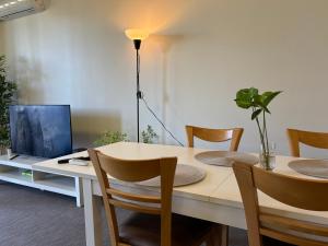 a dining room with a table with chairs and a television at Courtyard apartment in Perth
