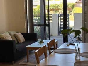 a living room with a couch and a table and chairs at Courtyard apartment in Perth