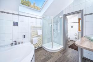 a bathroom with a tub and a shower and a sink at Allgäuer Panoramahotel in Oberstaufen +68 photos
