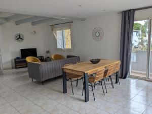 a living room with a wooden table and chairs at Sol-Y-Days Avenue Camargue, grande maison proche centre et mer in Le Grau-du-Roi +7 photos