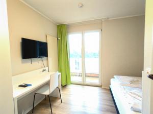 a room with a desk and a bed and a window at Bendorf Hotel by Belvilla in Bendorf