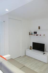 a living room with a tv on a white wall at Ca di baragett in Mandello del Lario