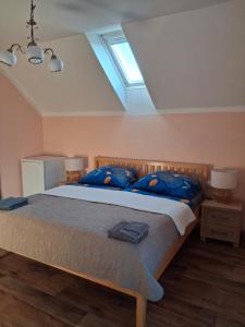 a bedroom with a large bed with blue pillows at Penzion Na Hradčanech in Nové Město nad Metují